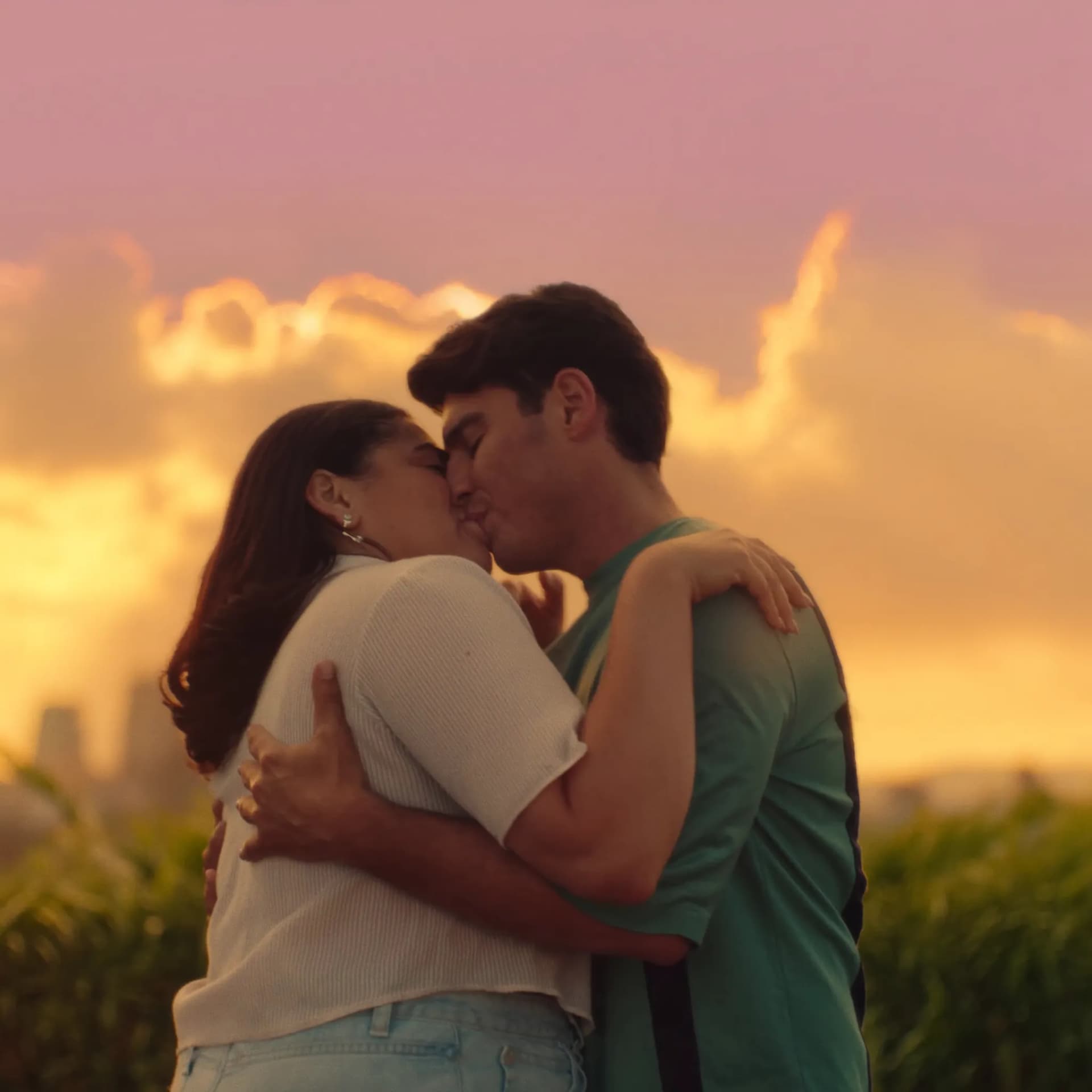 Casal jovem brasileiro se abraçando ao pôr-do-sol