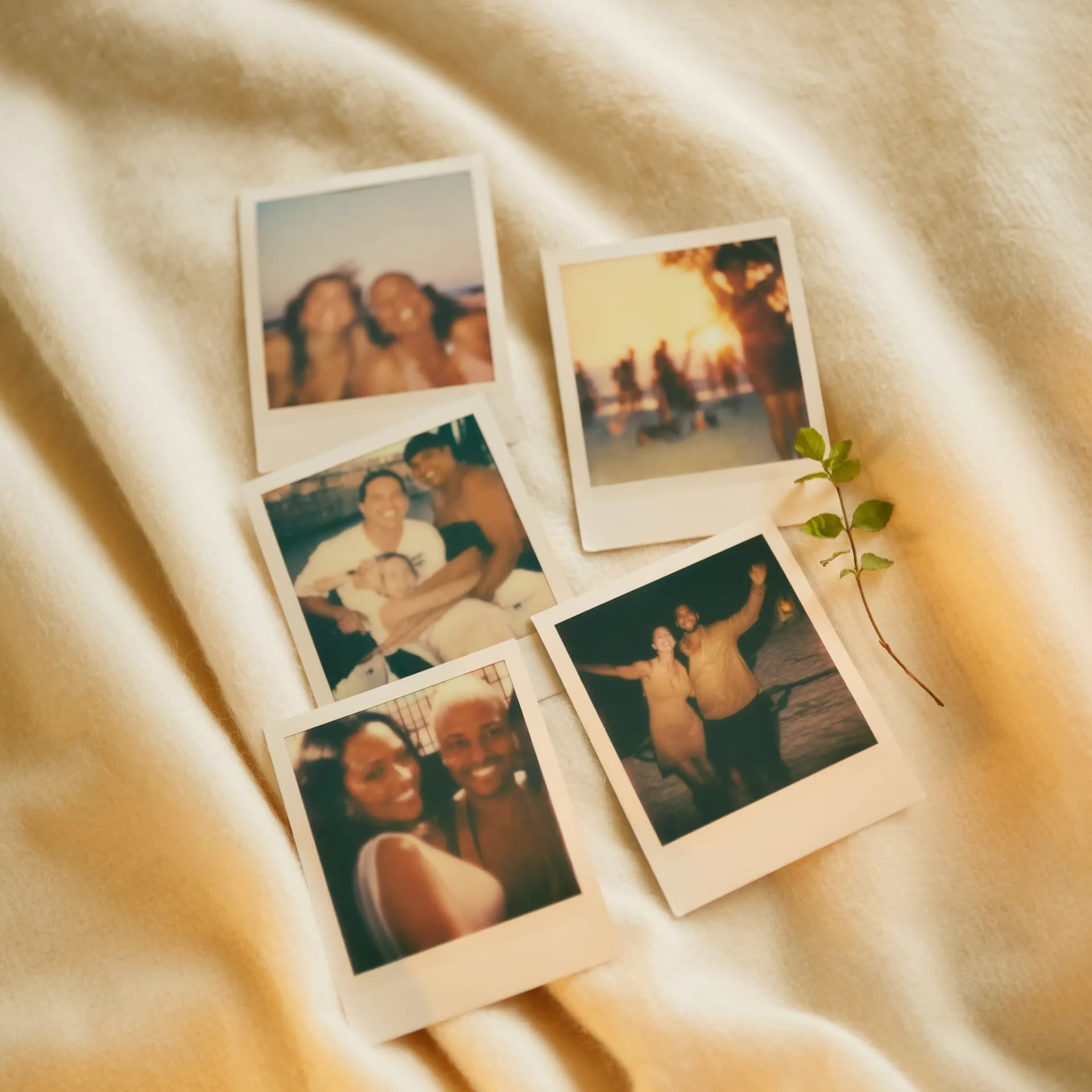 Polaroids espalhadas sobre cobertor em luz dourada