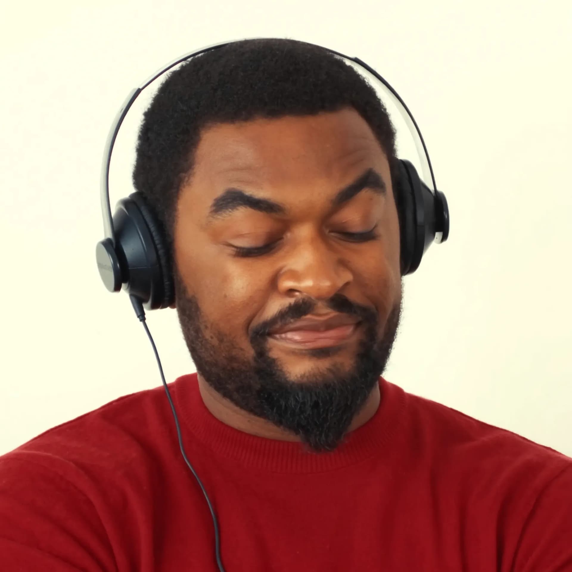 Homem com fones de ouvido sorrindo emocionado ao ouvir música